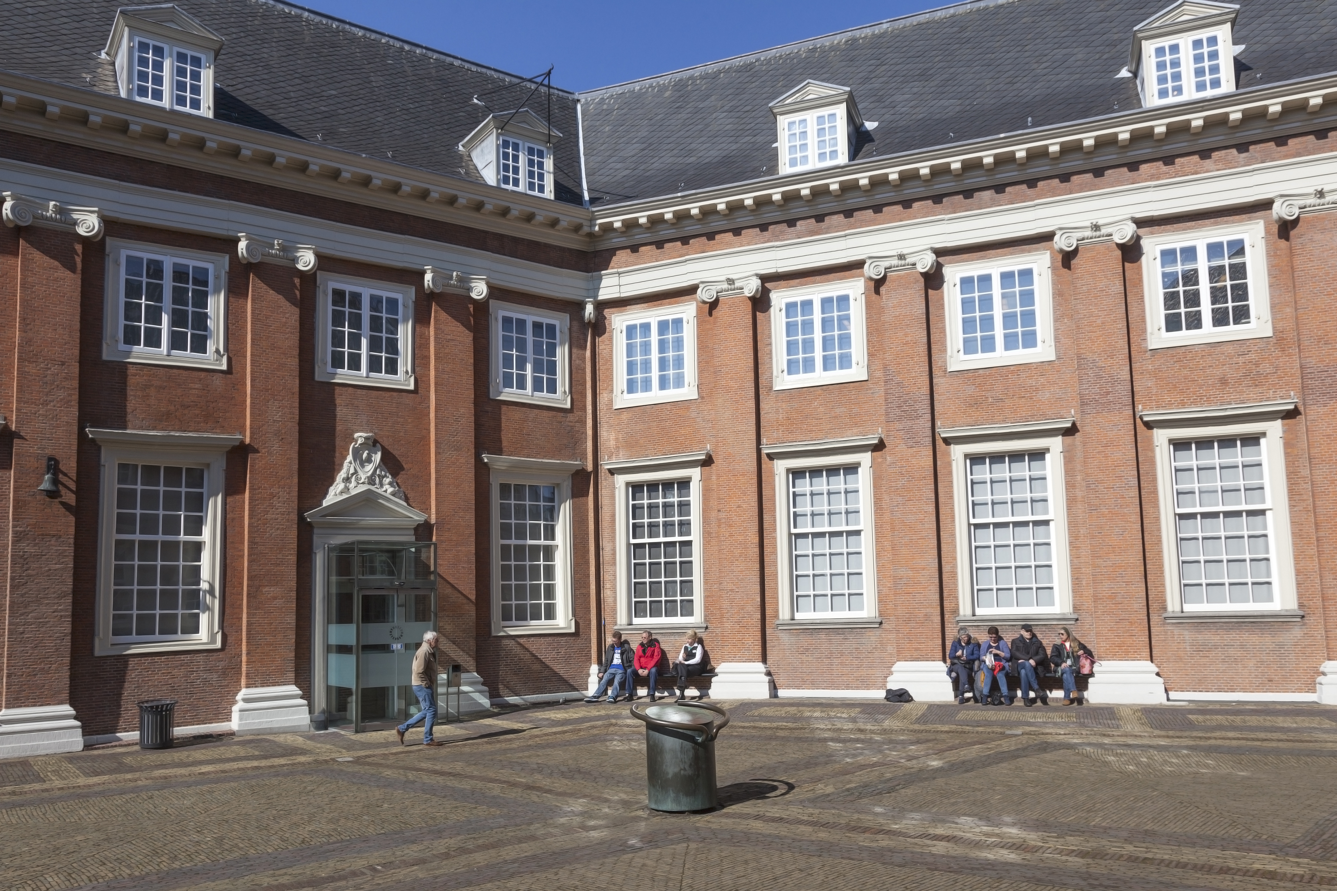 tourists enjoy the sun on central court of amsterdam museum
